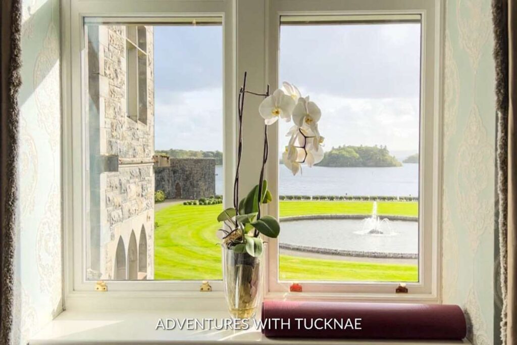 The view from our room in Ashford Castle. The window has an orchid on the sill and the view overlooks the gardens, fountain, and Lough Corrib below. 