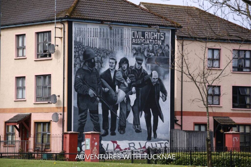 An art mural in Derry/Londonderry in Northern Ireland. The mural shows a war scene from the Civil Rights Association and is painted on the side of a building.