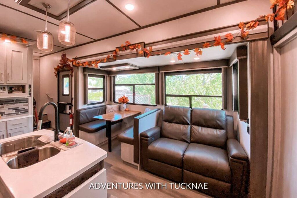 View of our living room in our RV decorated for fall with colorful leaf garland above the RV slide