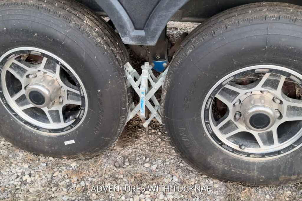 Two RV tires with an x-chock wheel stabilizer between them.