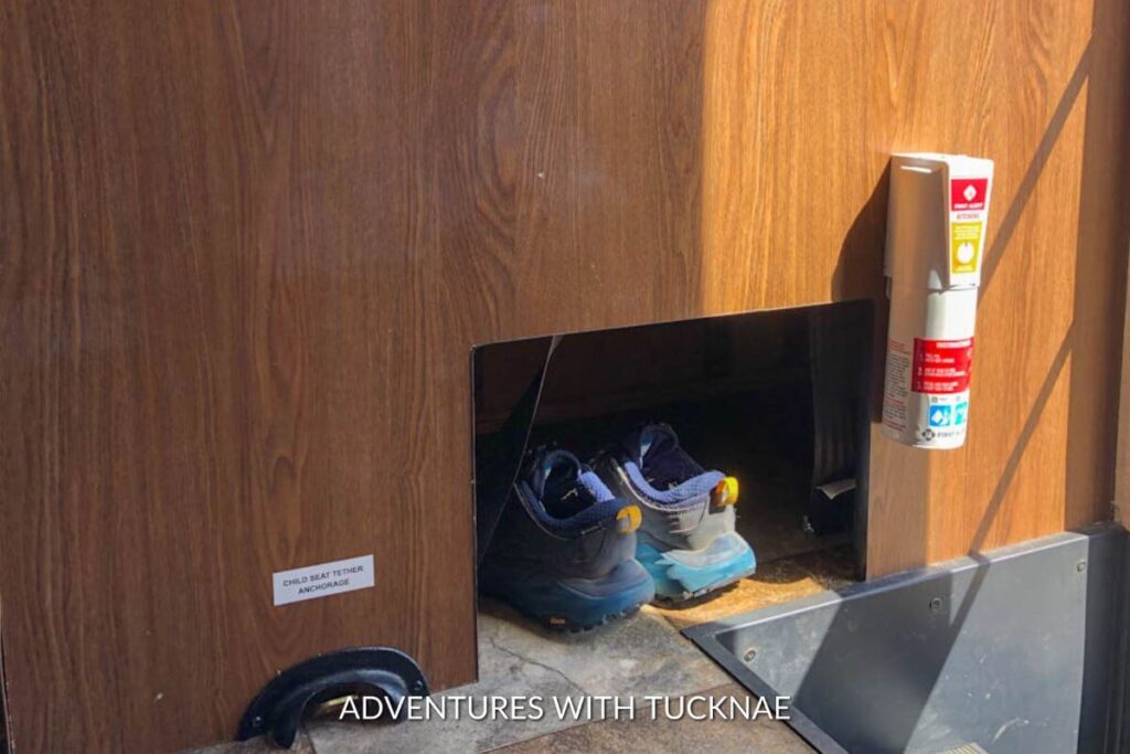 A Coachmen Leprechaun RV showing shoe storage under the dinette just inside the doorway