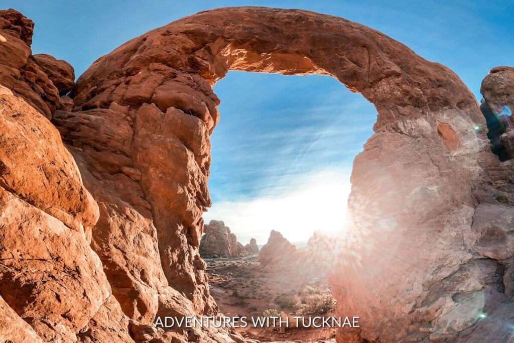 The sun rising behind Turret Arch in Arches National Park.