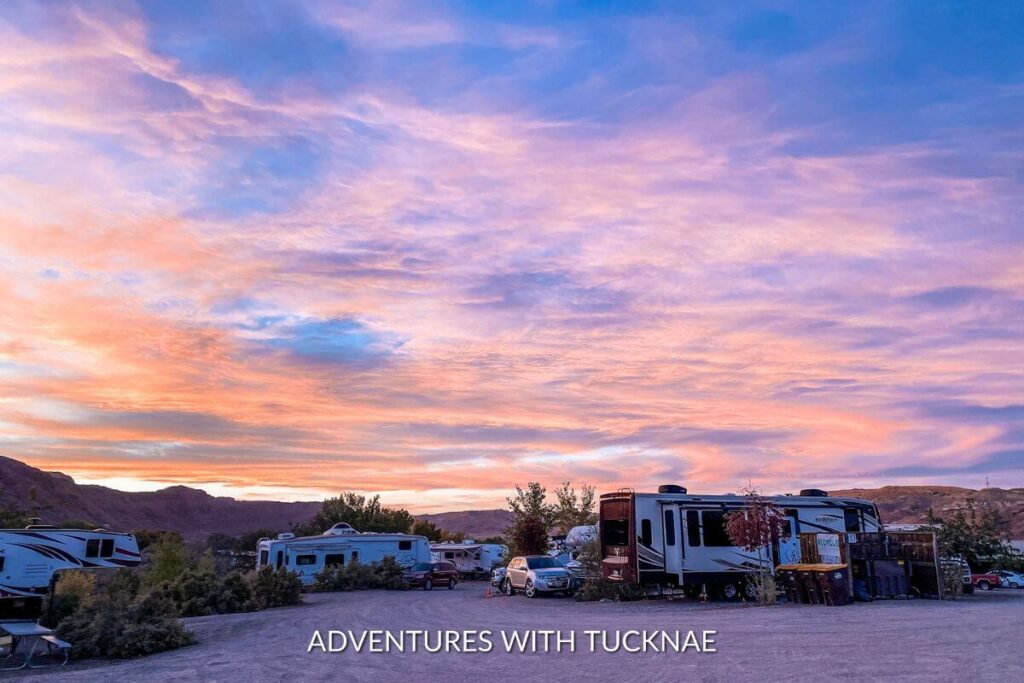 A beautiful pink, purple, orange, and blue sunset over an RV park in Moab, Utah.