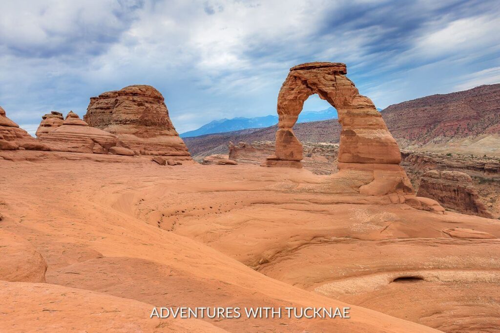 Delicate Arch in Arches National Park. The arch is in the distance and this is a beautiful desert scene.