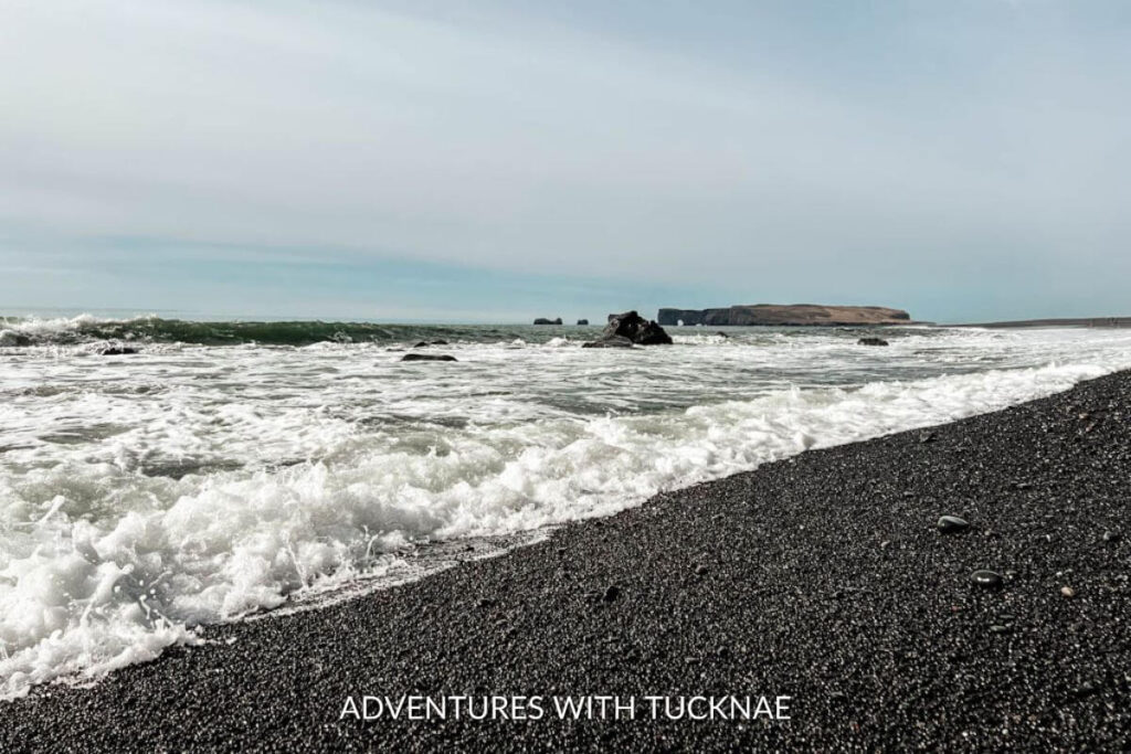 Ocean waves crashing against the black sand beach at Vik Iceland