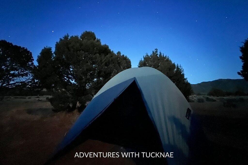 Astrophotography image of the stars in the night sky above a tent in the Utah desert