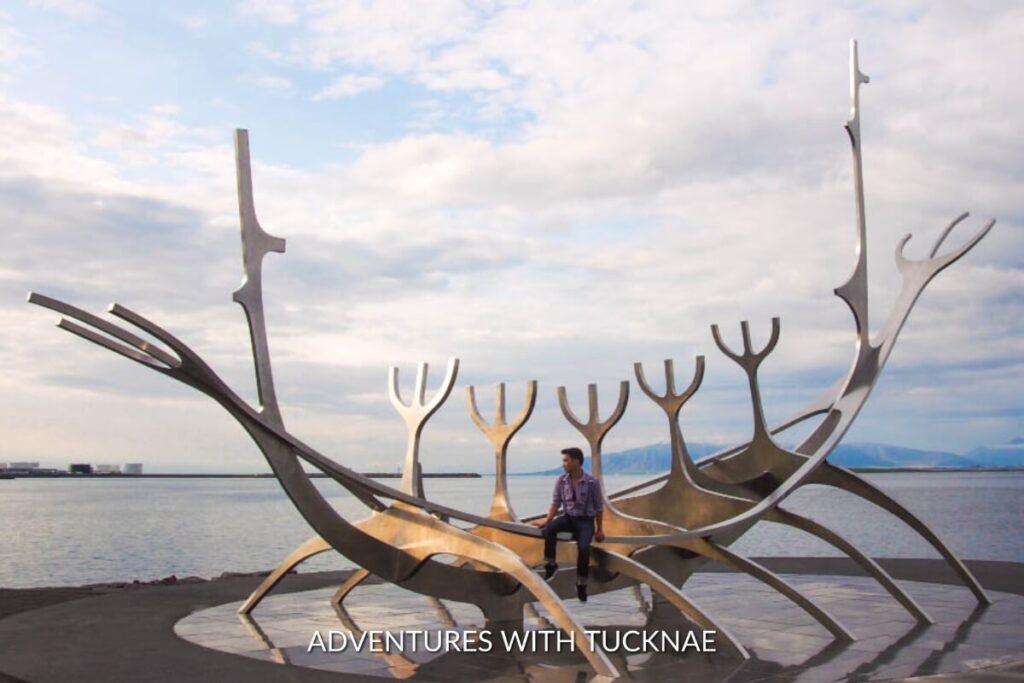 A man posing with The Sun Voyager in Reykjavik, Iceland