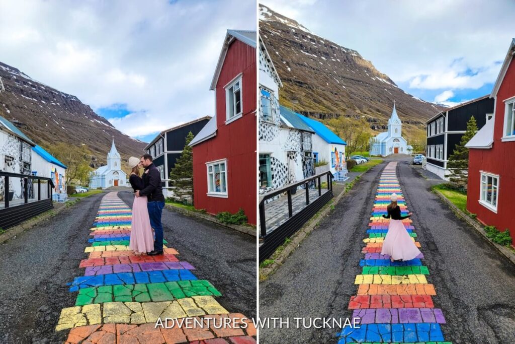 A couple posing on the rainbow road in Seyðisfjörður in Iceland