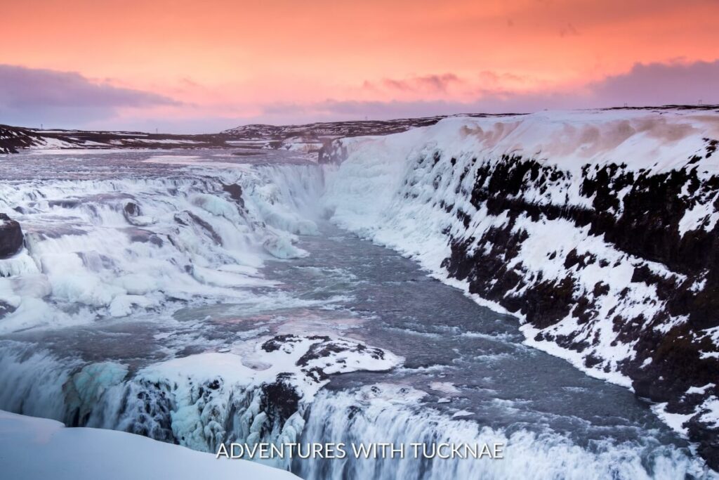 Gullfoss waterfall in Iceland in winter with a bright pink sky above