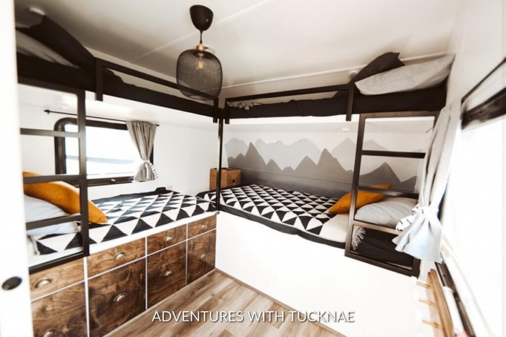 Mountain wallpaper in an RV bunk room with black and orange decor