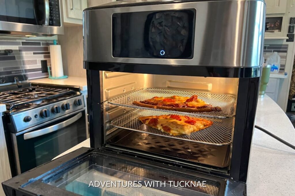 Slices of pizza in an air fryer in an RV kitchen