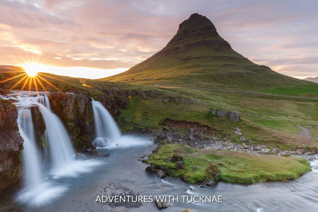 Kirkjufellsfoss, with Kirkjufell mountain in the distance, reflects the golden light of the setting sun, a magical moment at one of Iceland's best waterfalls.