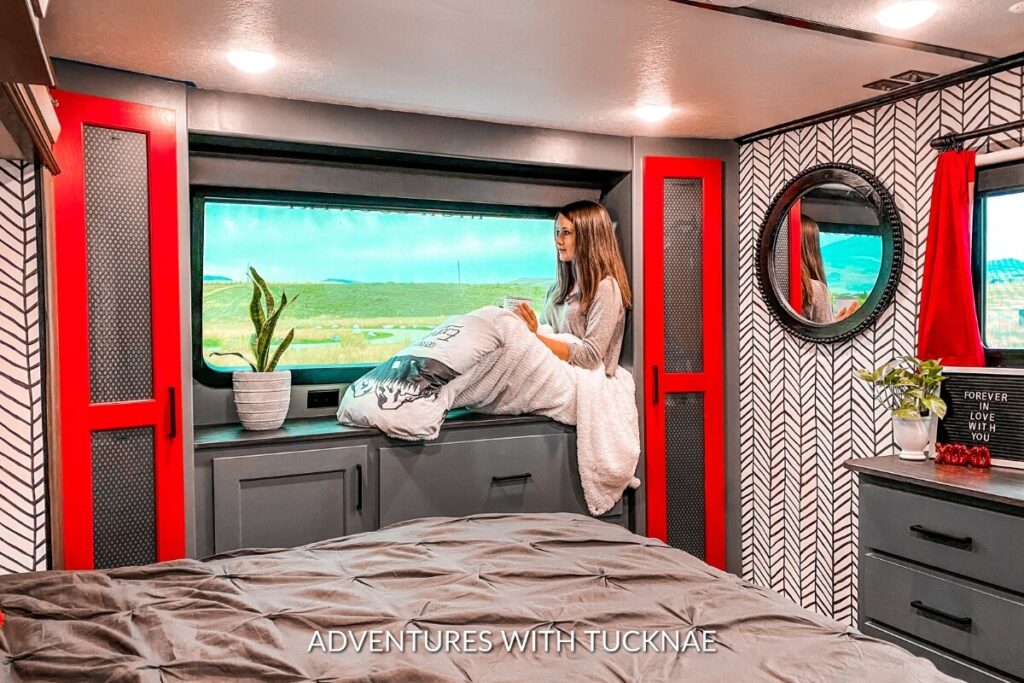 A girl sitting in a renovated bedroom in a Keystone Montana High Country 335BH 5th wheel RV