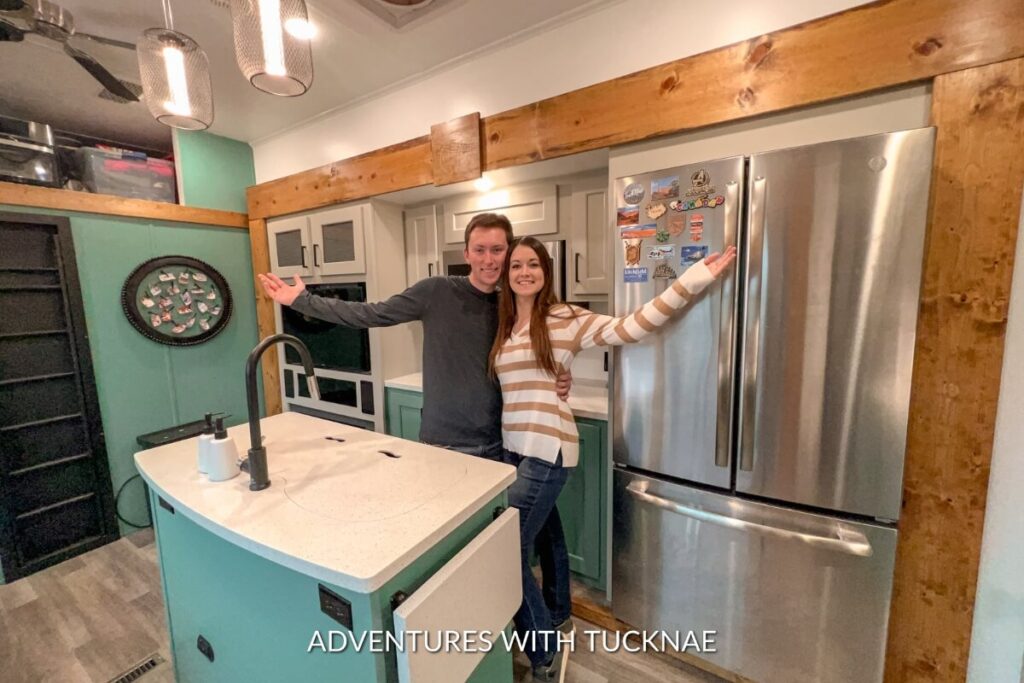 A couple standing in the renovated RV kitchen of their Keystone Montana High Country 335BH travel trailer