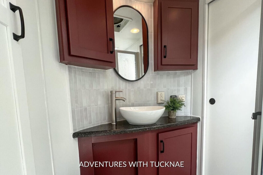 A unique RV bathroom renovation with maroon-painted cabinets
