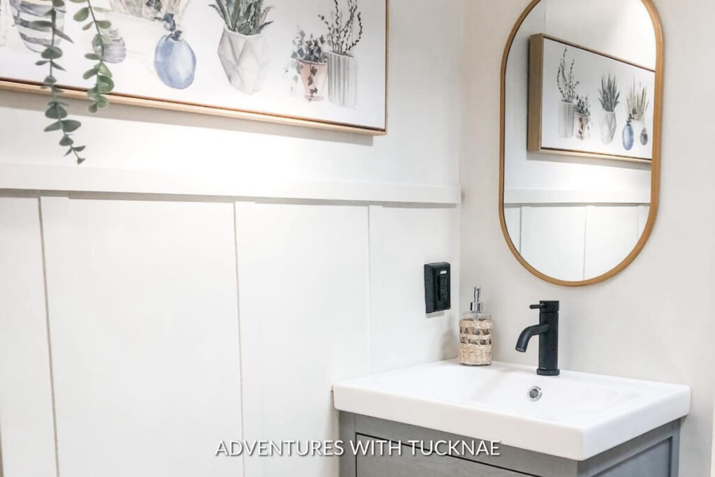 A modern RV bathroom renovation with plant art on the wall