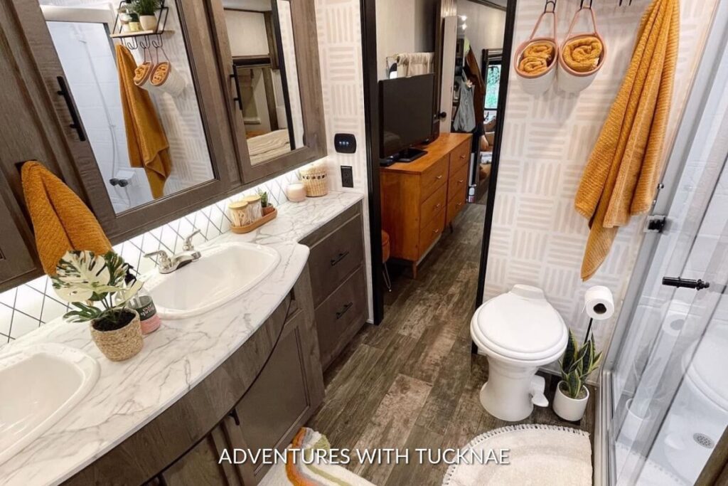 A bright and cozy RV bathroom renovation with orange accents