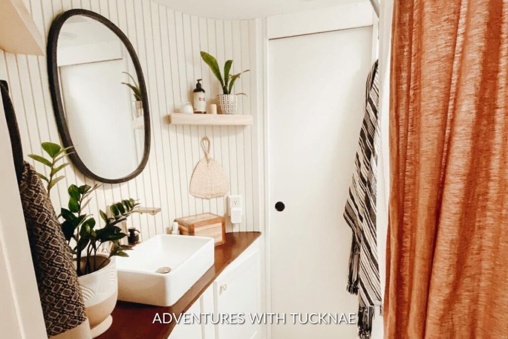 A bohemian-style RV renovation with a rust-colored shower curtain