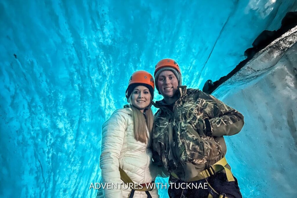 A couple standing in a blue ice cave in Iceland