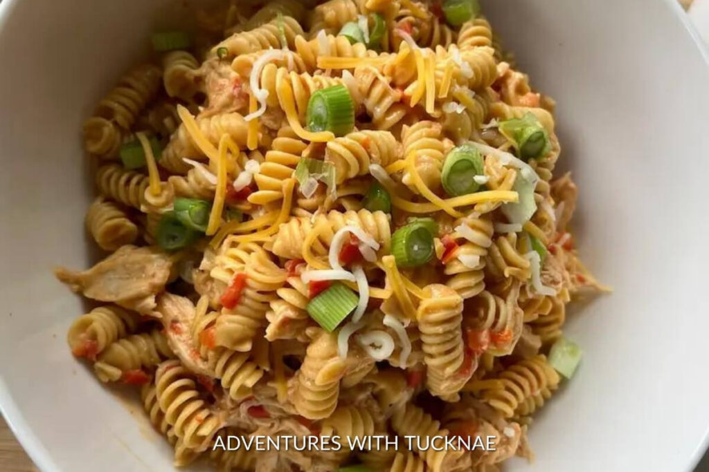 Spicy buffalo chicken crockpot pasta with cheese and green onions, a perfect dish to enjoy while RV camping.