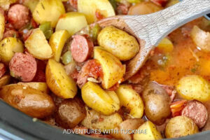 A rustic crockpot casserole with sausages, potatoes, and colorful vegetables, an ideal RV camping crockpot meal.