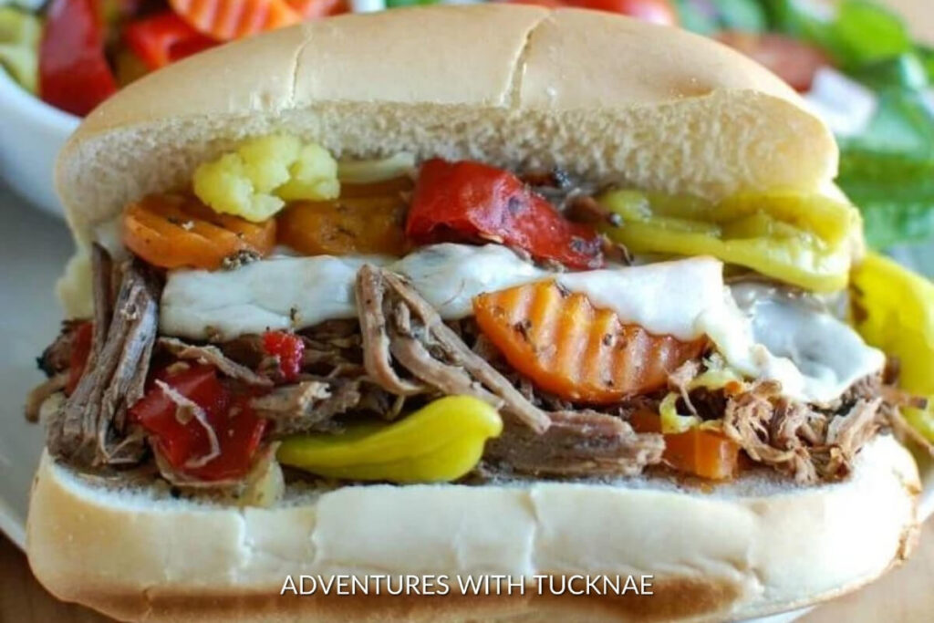 Juicy slow cooker Italian beef sandwiches topped with melted cheese, great for camping crockpot recipes.