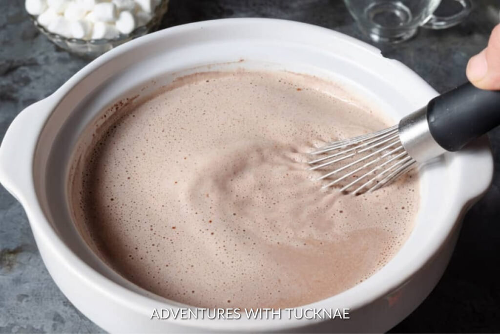 A creamy and rich crockpot hot chocolate mix being whisked to smooth perfection, a sweet treat to enjoy while rv camping.