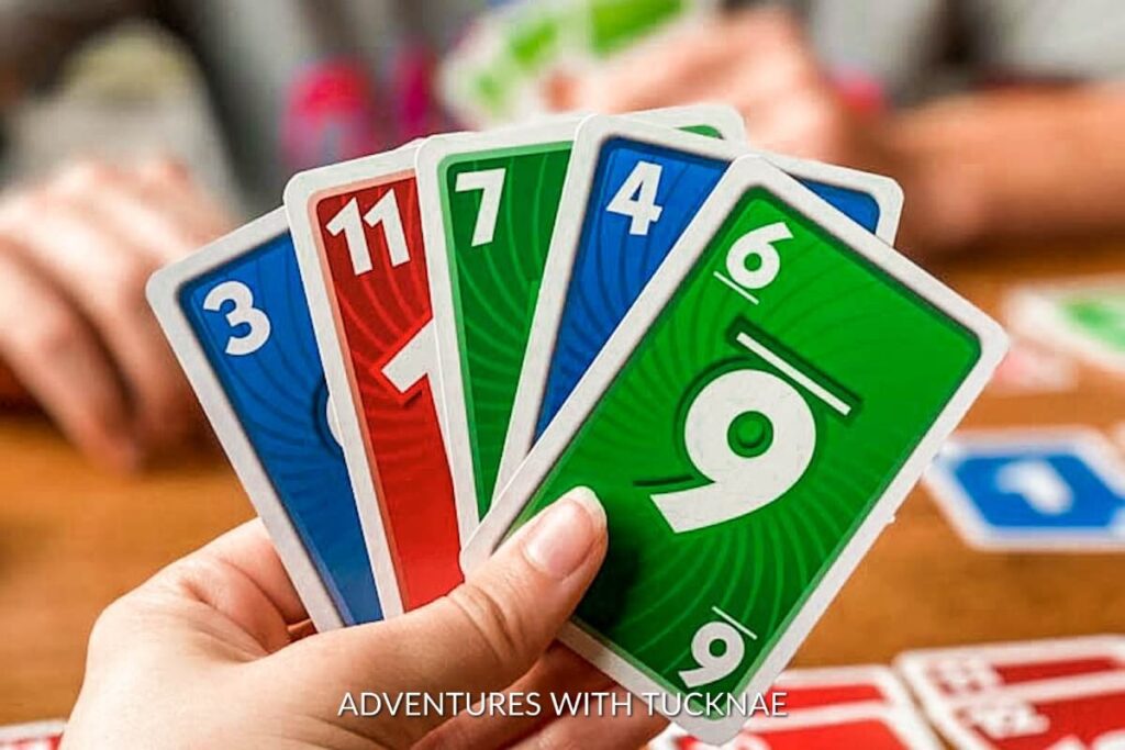 Close-up of a person's hand holding various Uno cards during a game, implying board games as entertaining gifts for RV trips.