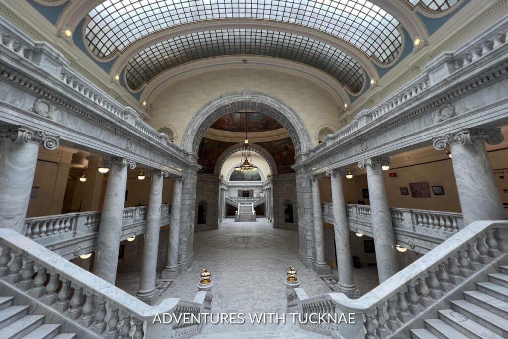 The grand interior of the Utah State Capitol, featuring elegant marble columns and a stunning rotunda, exemplifies neoclassical architecture in an instagrammable setting.
