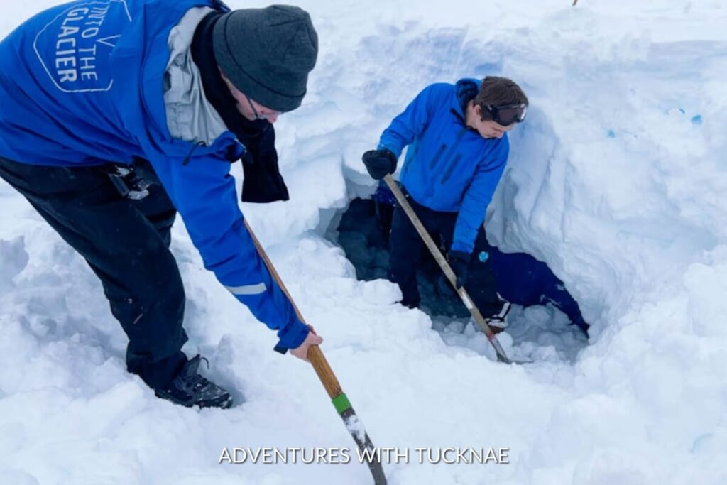 Guides digging through the snow at Into the Glacier, working together to clear a path or conduct research.