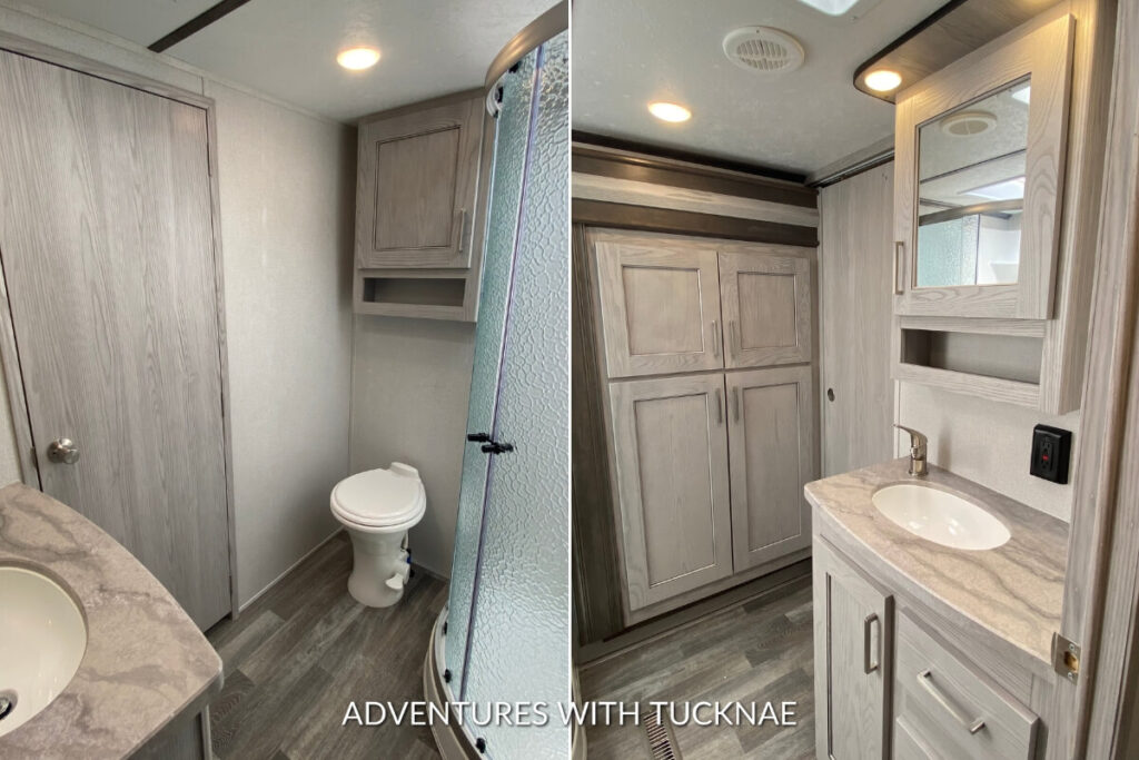 Interior view of a Keystone Montana High Country RV's master bathroom with a glass-enclosed shower and wooden cabinets.
