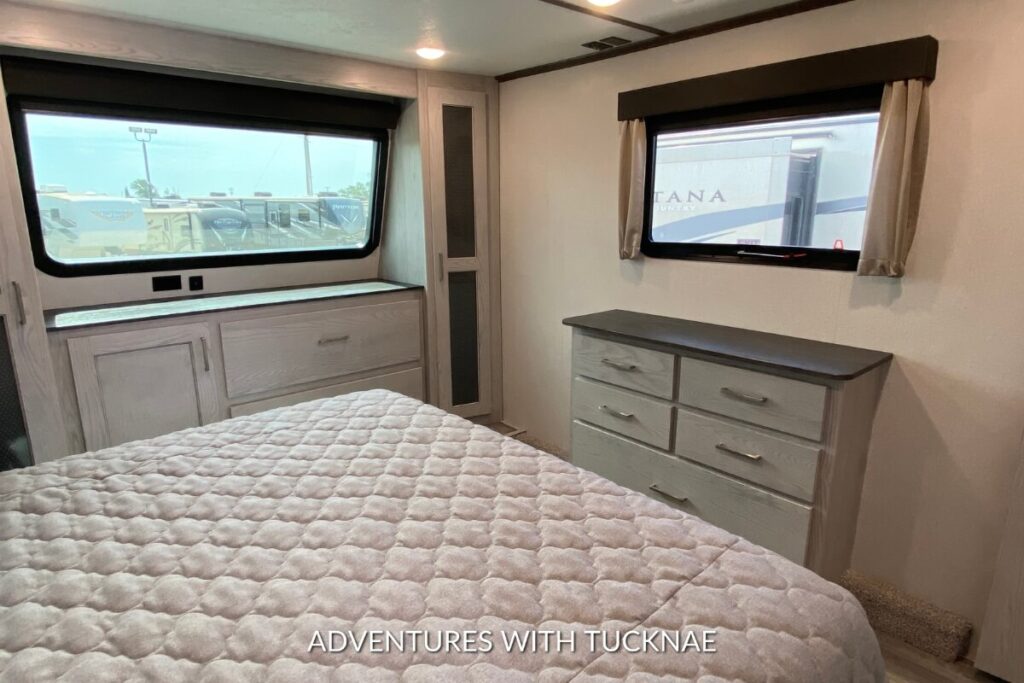 Different angle of the Keystone Montana RV's master bedroom showing the window, built-in dresser, and additional storage.