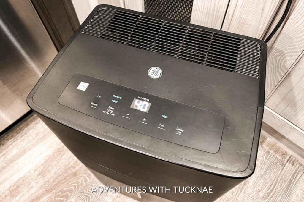 A black portable GE dehumidifier with a digital display showing a humidity level of 40% in an RV.