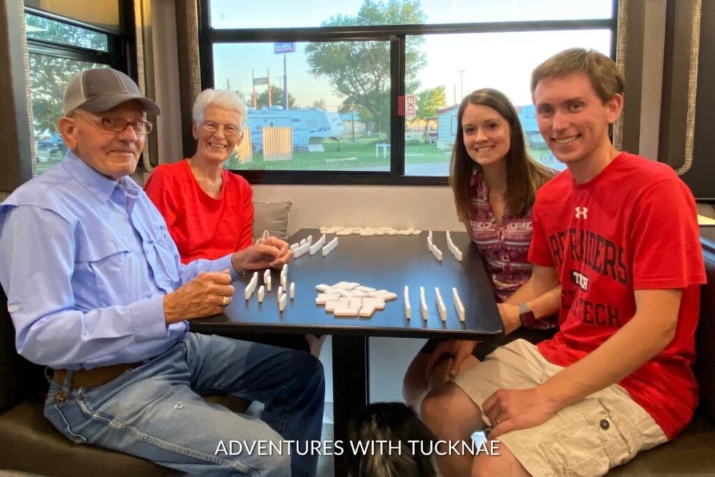 A group of people playing Mexican Train Dominoes in an RV