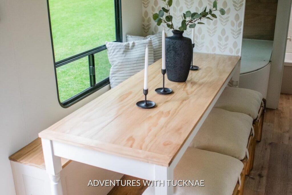 Light wood dining table with black candlesticks in an RV, a modern take on RV table design.