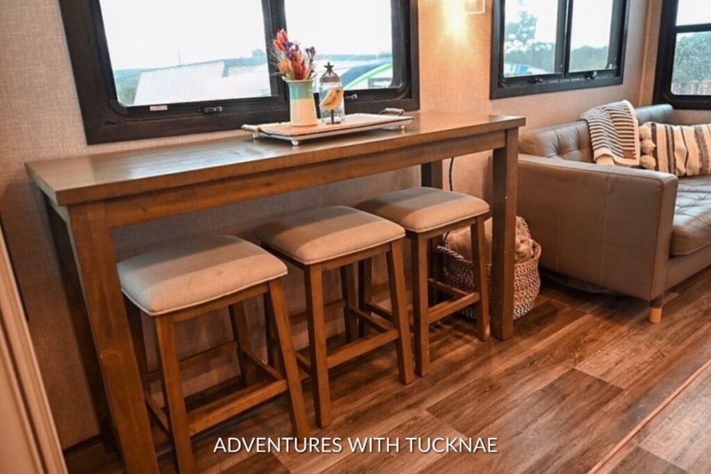 Inviting RV space with a rustic wooden table and metal stools, a classic example of space-efficient RV dining solutions.