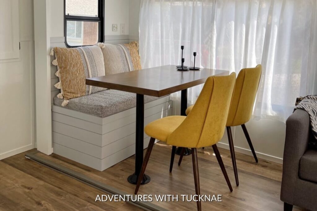 Bright RV interior with a wooden table, accented by vibrant yellow chairs, a contemporary approach to RV table design.