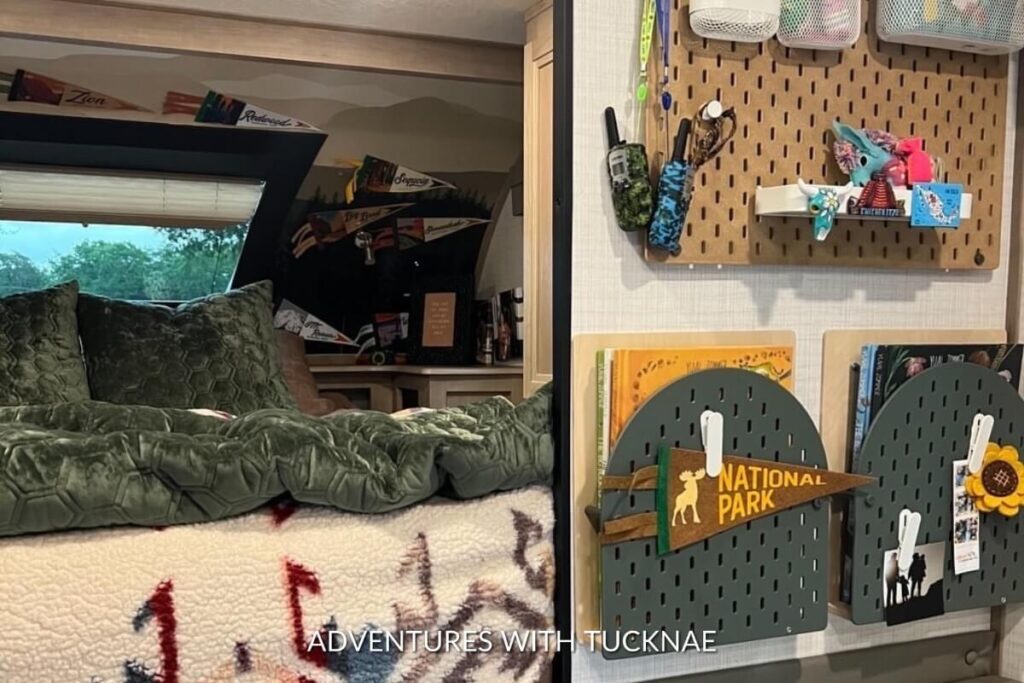 RV bunk space adorned with a variety of travel books above and a unique pegboard with national park themed decorations, set against a forest-patterned wallpaper.