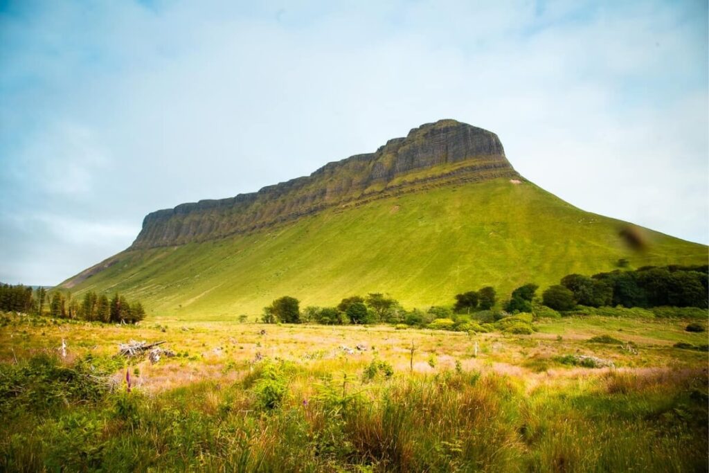 The distinctive flat top of Benbulbin mountain rises above the green fields, a natural landmark and a stunning Instagram spot in Ireland.