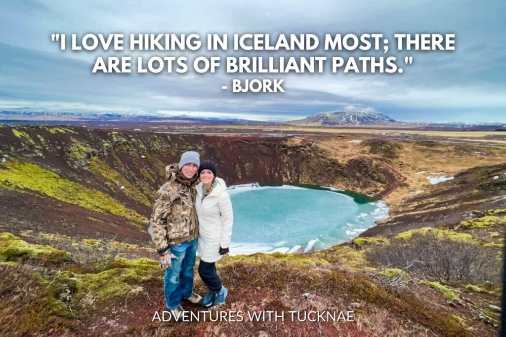 A couple stands before a stunning view of a volcanic crater lake in Iceland with the quote, "I love hiking in Iceland most; there are lots of brilliant paths." by Björk.