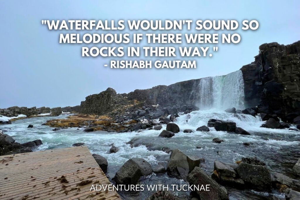 A picturesque Icelandic waterfall flows amidst snow-covered rocks with the quote, "Waterfalls wouldn't sound so melodious if there were no rocks in their way." by Rishabh Gautam.