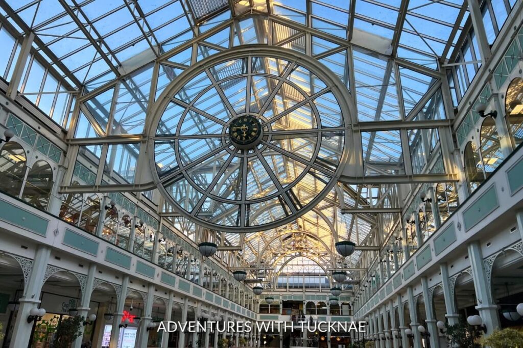 Intricate ironwork and glass ceiling of the Victorian-era shopping area on Grafton Street, a top Instagrammable Place in Dublin, with a historical clock.