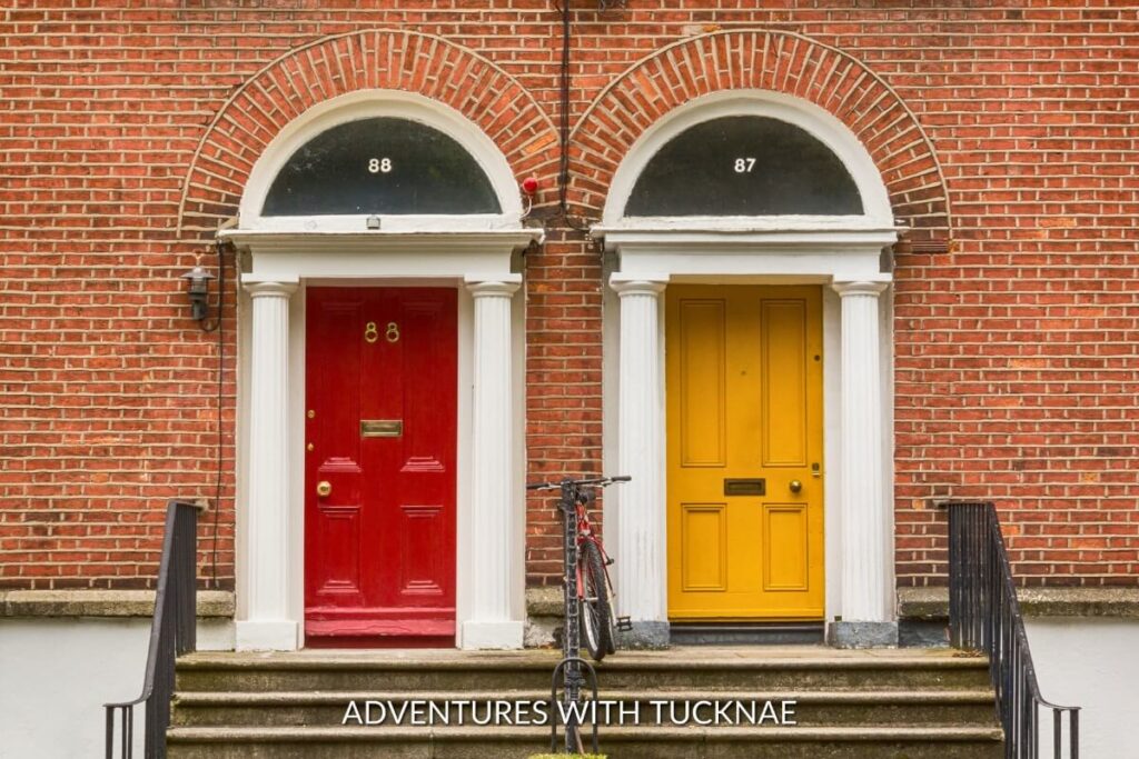 Iconic Instagrammable red and yellow Georgian doors of Dublin, with classical architecture and a vintage bicycle parked outside.