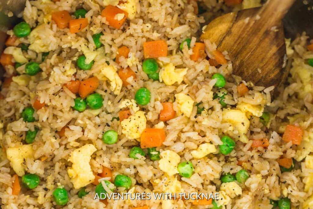Instant Pot Fried Rice Hibachi: Close-up of Instant Pot fried rice hibachi style, featuring colorful peas, carrots, and egg bits, perfect for an outdoor feast.