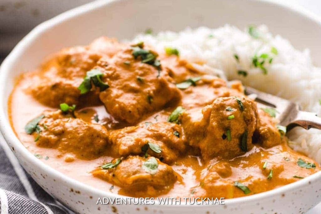 Instant Pot Butter Chicken: Creamy and rich Instant Pot butter chicken in a white bowl, garnished with fresh cilantro alongside fluffy rice, ideal for a camping dinner.