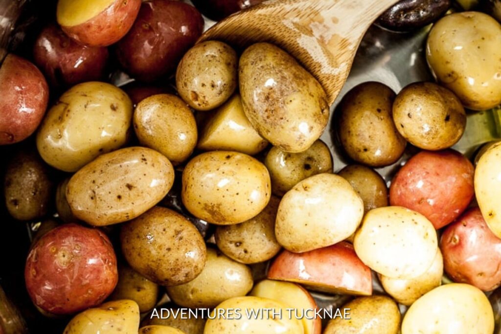 Instant Pot Baby Potatoes: Glossy Instant Pot baby potatoes with a mix of red and gold skins, freshly cooked and seasoned, ready for a campfire side dish.