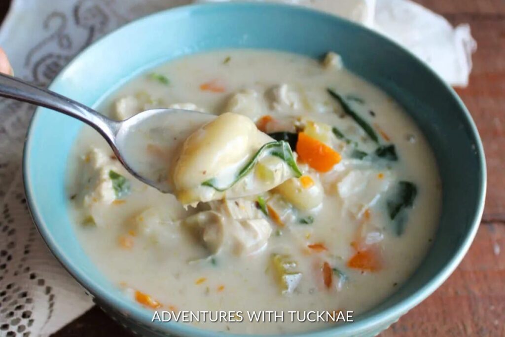 Instant Pot Chicken Gnocchi Soup: Creamy Instant Pot chicken gnocchi soup served in a blue bowl, featuring tender chicken pieces, gnocchi, and diced vegetables.