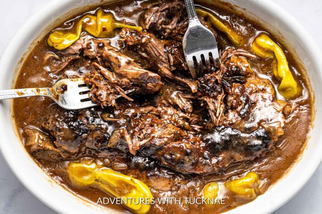 Instant Pot Mississippi Pot Roast: A close-up of tender Instant Pot Mississippi pot roast on a white plate, garnished with pepperoncini, and ready for a comforting meal.
