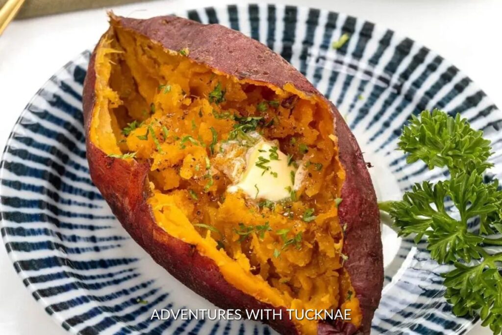 A bright orange Instant Pot Sweet Potato, split open to reveal a fluffy interior with a pat of butter and fresh herbs, a nutritious addition to any camping meal plan.