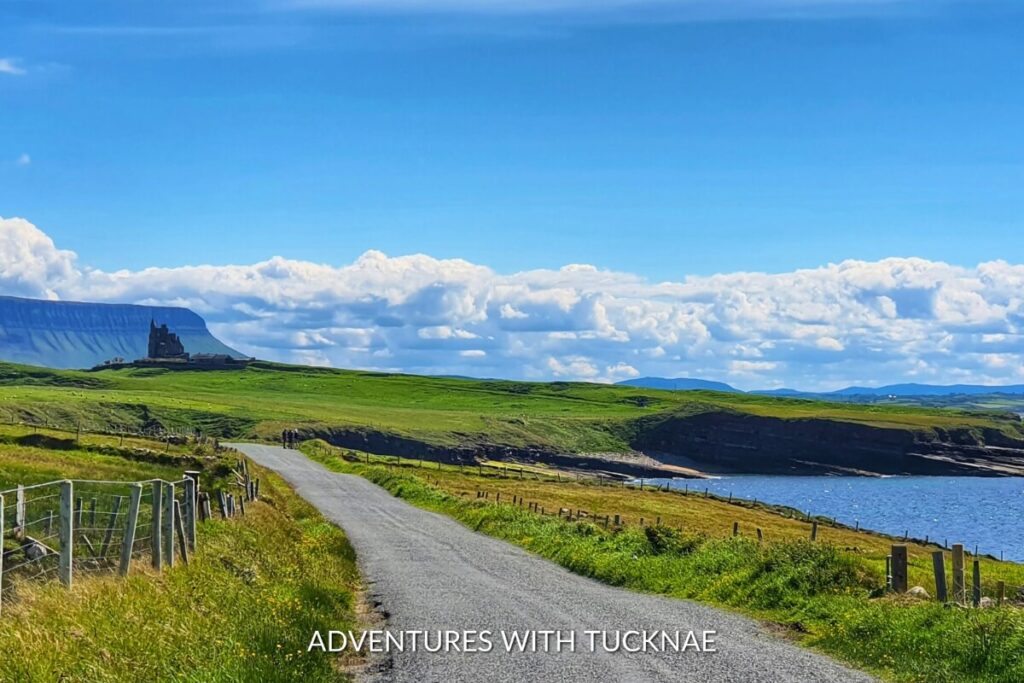 A scenic coastal road leads to Mullaghmore Beach with a view of Classiebawn Castle against the backdrop of mighty Benbulbin, an Instagram-worthy spot in Ireland.